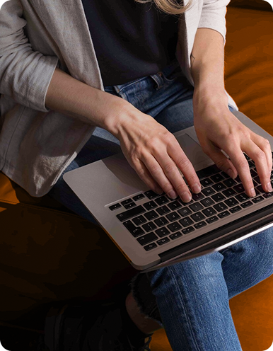 Person sitting down while typing on a laptop.